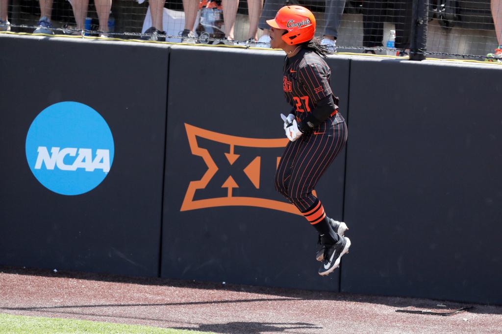 Oklahoma State utility Jilyen Poullard (27) celebrates after scoring a run in the first inning a softball game between the Oklahoma State Cowgirls and Michigan in the finals of the Stillwater Regional of the NCAA Tournament