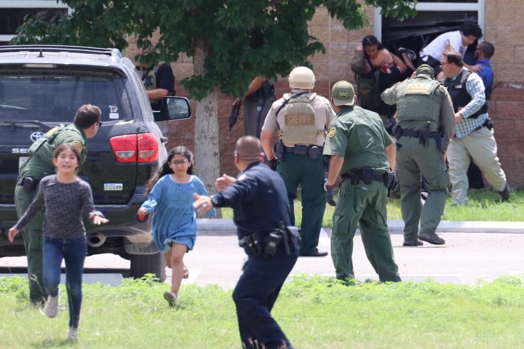 Children run to safety after escaping from a window during a mass shooting at Robb Elementary School where a gunman killed nineteen children and two adults in Uvalde, Texas, U.S. May 24, 2022.