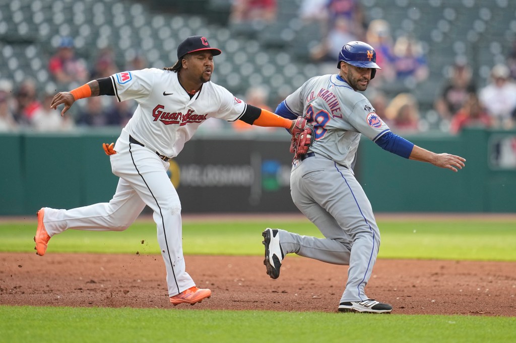 Guardians third base Jose Ramirez, left, tags out New York Mets' J.D. Martinez, right, between second and third base in the second inning on Monday.