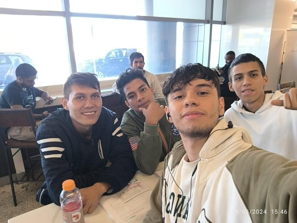 Ricardo and Sebastian take a selfie with fellow migrants at the Phoenix airport