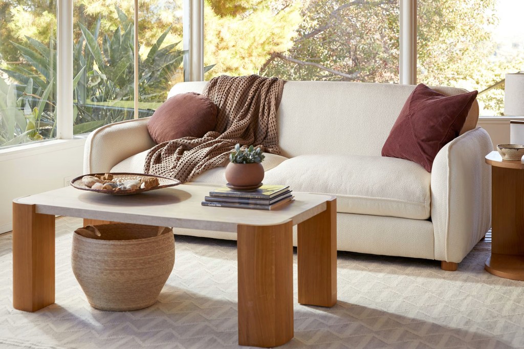 A couch with a blanket and a coffee table