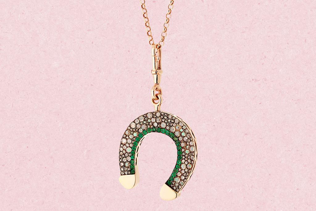 A gold horseshoe necklace adorned with diamonds and gems