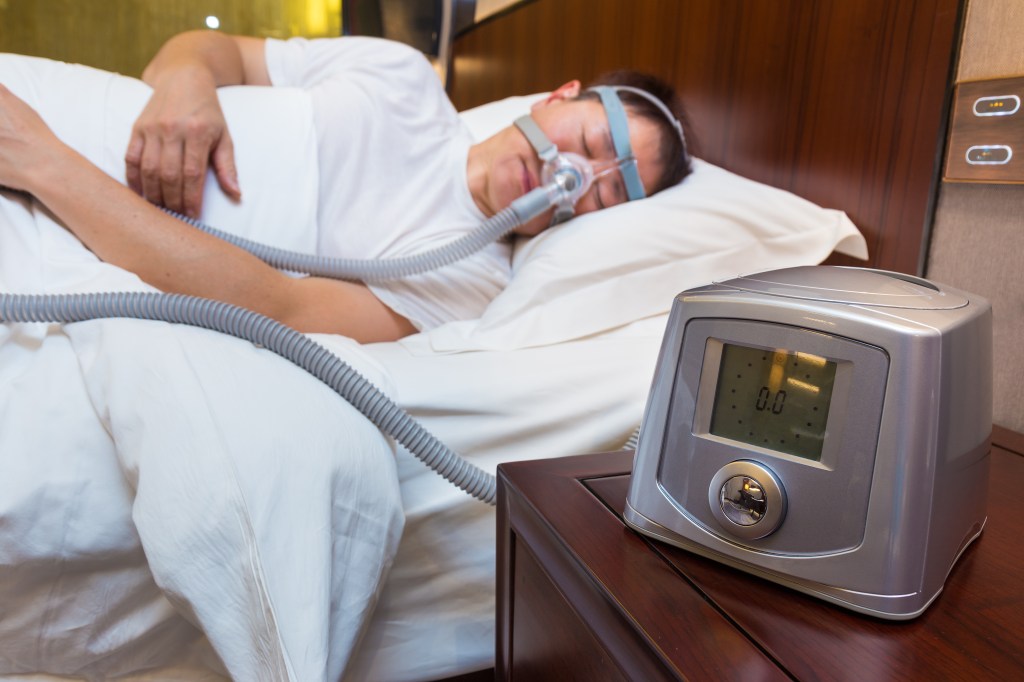 Man wear CPAP machine in bed