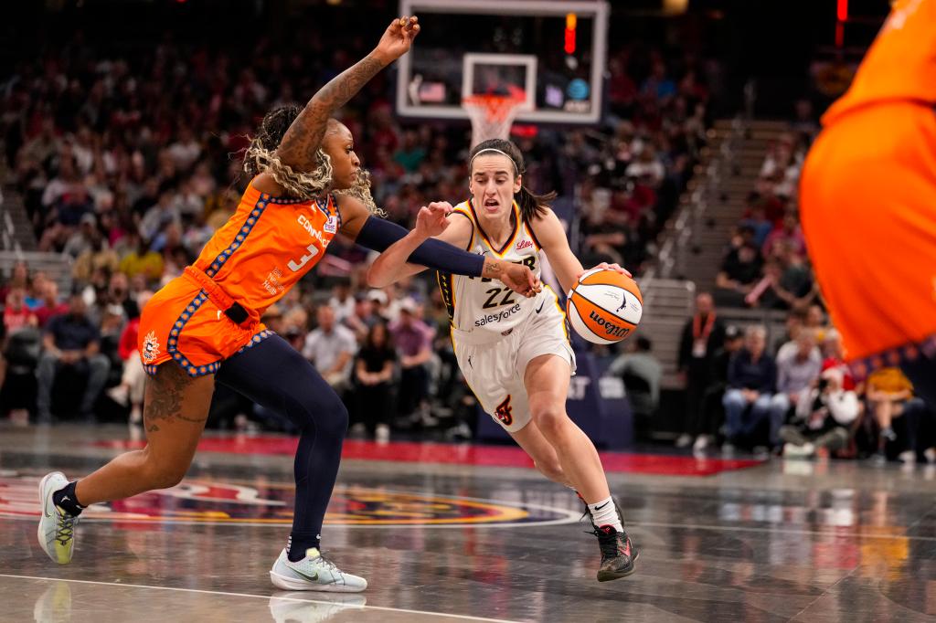 Indiana Fever guard Caitlin Clark (22) drives on Connecticut Sun guard Tiffany Mitchell (3) in the second half of a WNBA basketball game in Indianapolis, Monday, May 20, 2024.