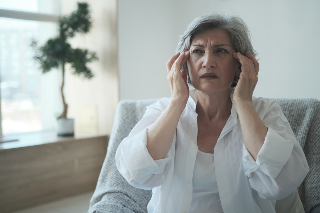 woman with hands to her head trying to think