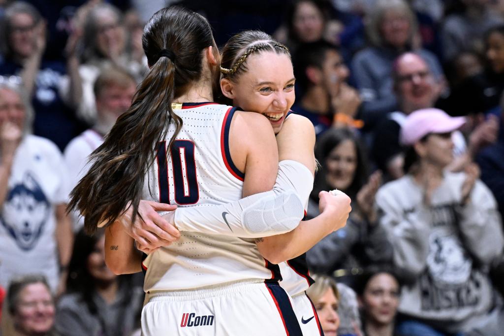 UConn guard Nika Muhl (10) is embraced by guard Paige Bueckers, right, when she comes out of the second half of an NCAA college basketball game against Georgetown in the finals of the Big East Conference tournament at Mohegan Sun Arena, Monday, March 11, 2024, in Uncasville, Conn.  