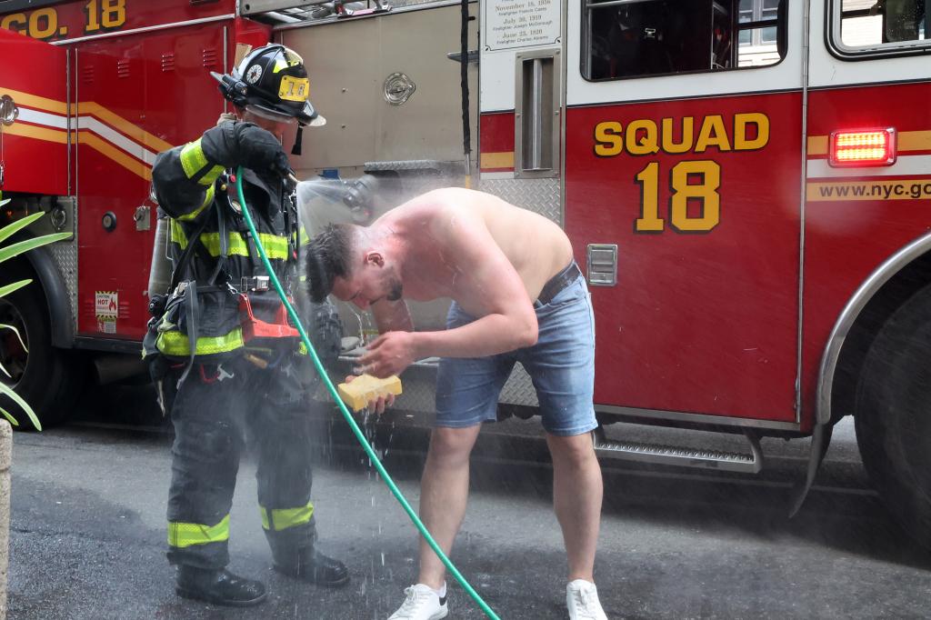 FDNY firefighter hosing down a victim who was set afire on a subway train.