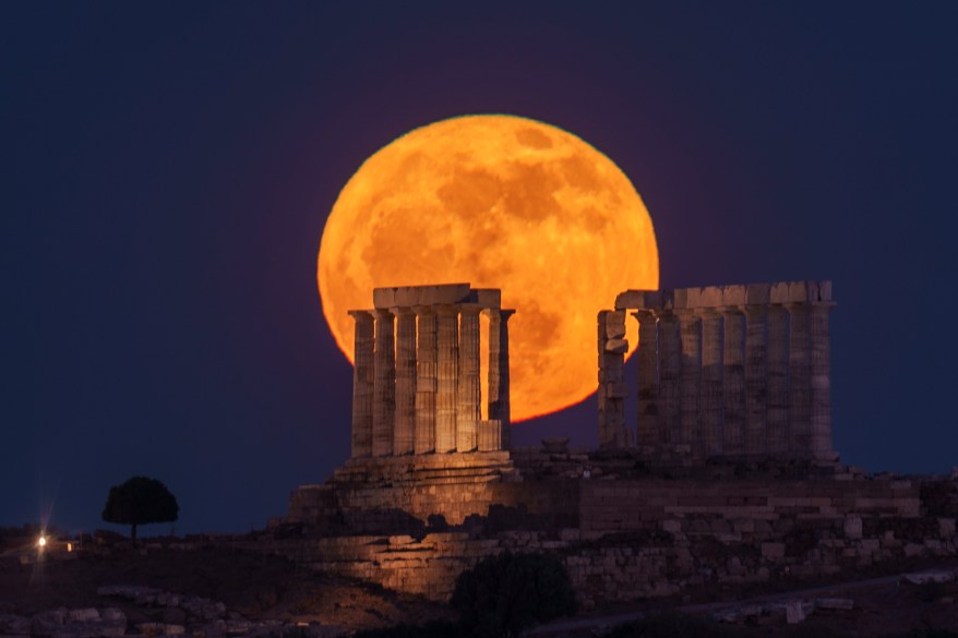 Moon rises behind the ancient temple of Poseidon near Athens, Greece.