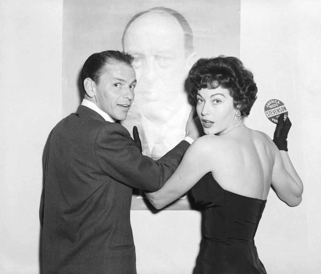 black and white photo of Frank Sinatra and Ava Gardner with a large poster of adlai stevenson behind them