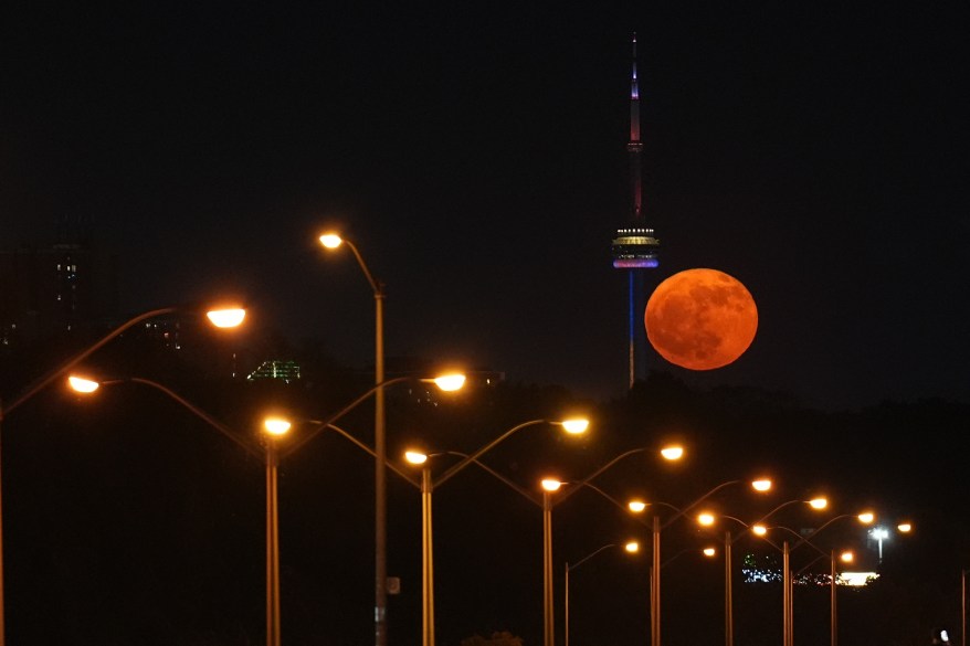 Moon rises over the CN Tower in Toronto, Canada.