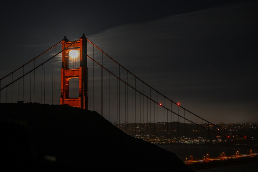 Moon rises over San Francisco's Golden Gate Bridge.