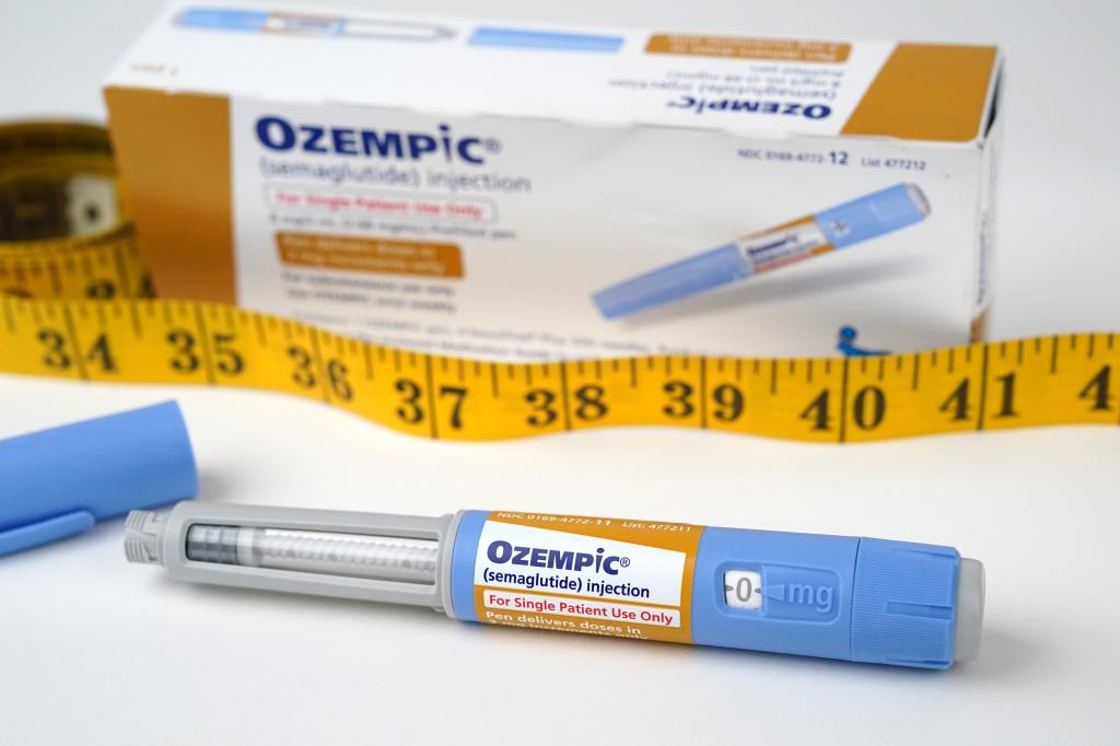 A box of Ozempic, with the injection open and a tape measure.