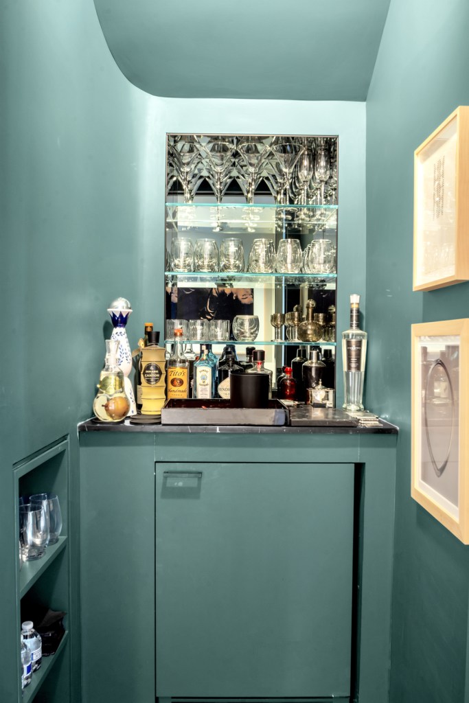 A colorful wet bar tucked away by the stairs.
