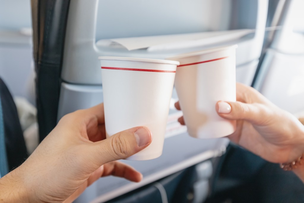 closeup of hands cheersing with plastic cups
