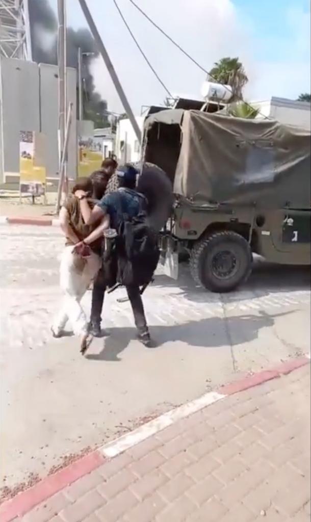 Hamas terrorists bringing IDF hostages to a truck.