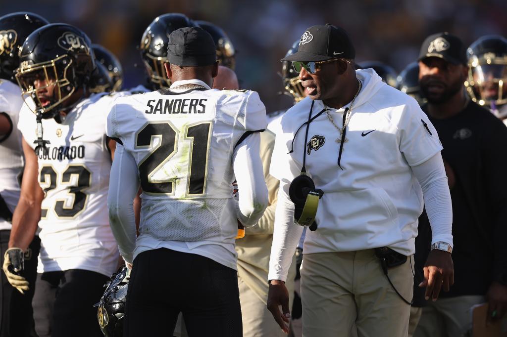 Head coach Deion Sanders of the Colorado Buffaloes talks with safety Shilo Sanders #21 of the Colorado Buffaloes during first half of the NCAAF game against the Arizona State Sun Devils at Mountain America Stadium on October 07, 2023 in Tempe, Arizona. The Buffaloes defeated the Sun Devils 27-24.