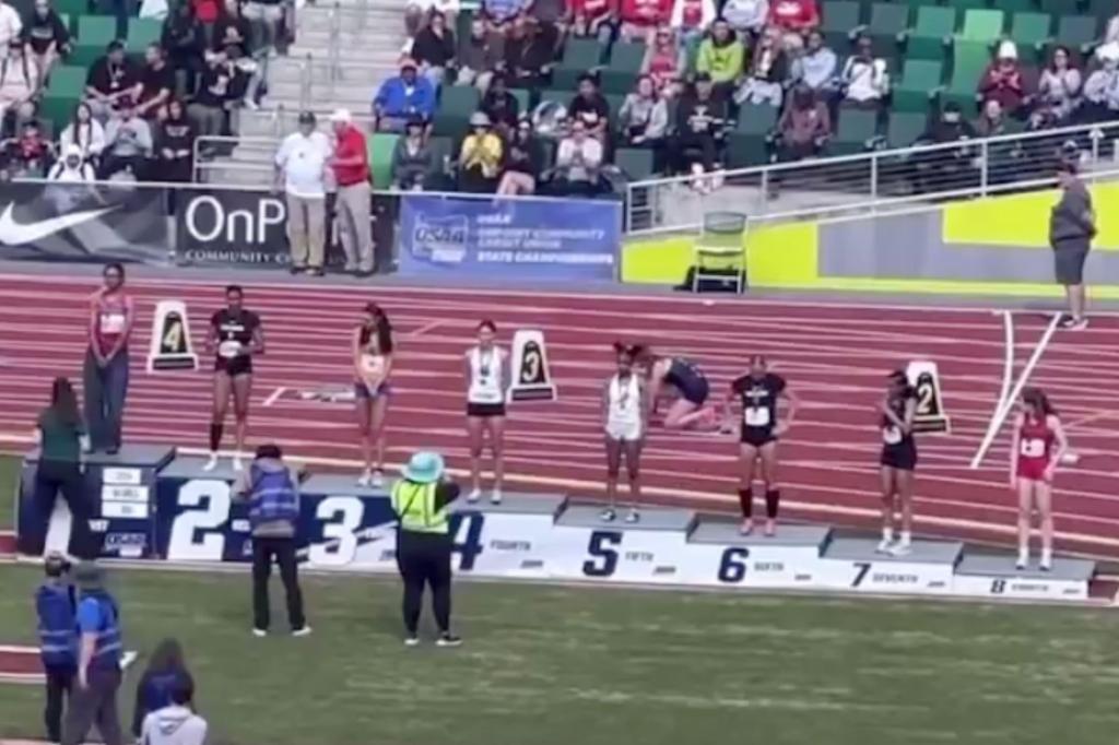 Transgender high school runner Aayden Gallagher being crowned as the 200-meter state champion on a track in Oregon, amidst a booing crowd