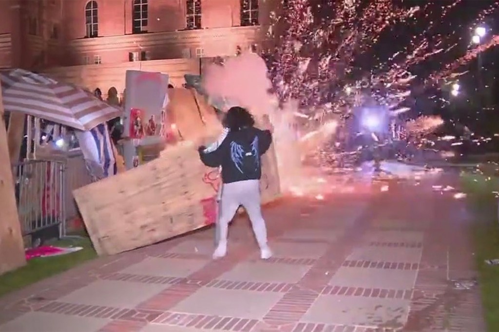 A firecracker explodes alongside a makeshift barricade set up at UCLA on April 30, 2024.