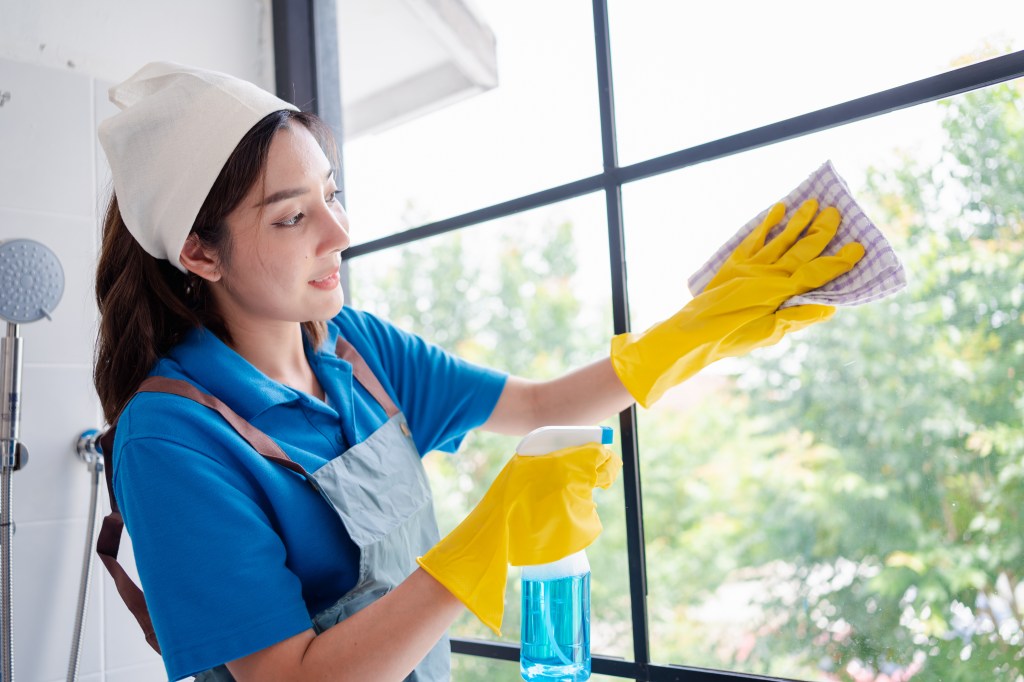 Housekeeper cleaning windows