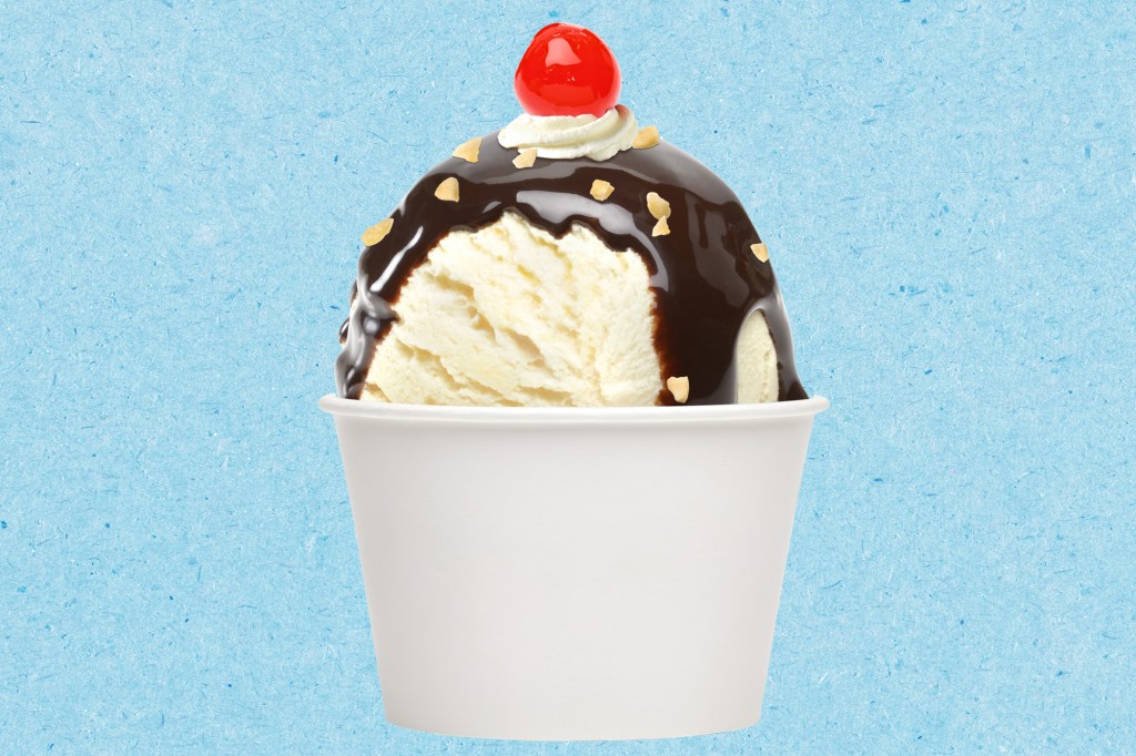 A cup of ice cream with chocolate sauce and a cherry on top on a blue paper texture background
