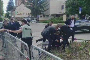 Security personnel carrying Slovakia's Prime Minister Robert Fico towards a vehicle after he was shot, taken from video footage