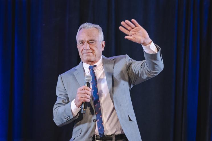 Robert F. Kennedy Jr. speaking at a campaign event in Holbrook, New York, holding a microphone