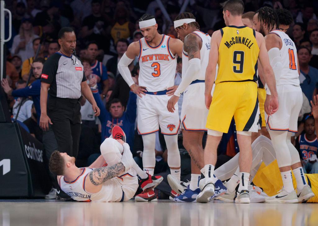 Knicks center Isaiah Hartenstein #55 grabs his ankle during the first quarter.