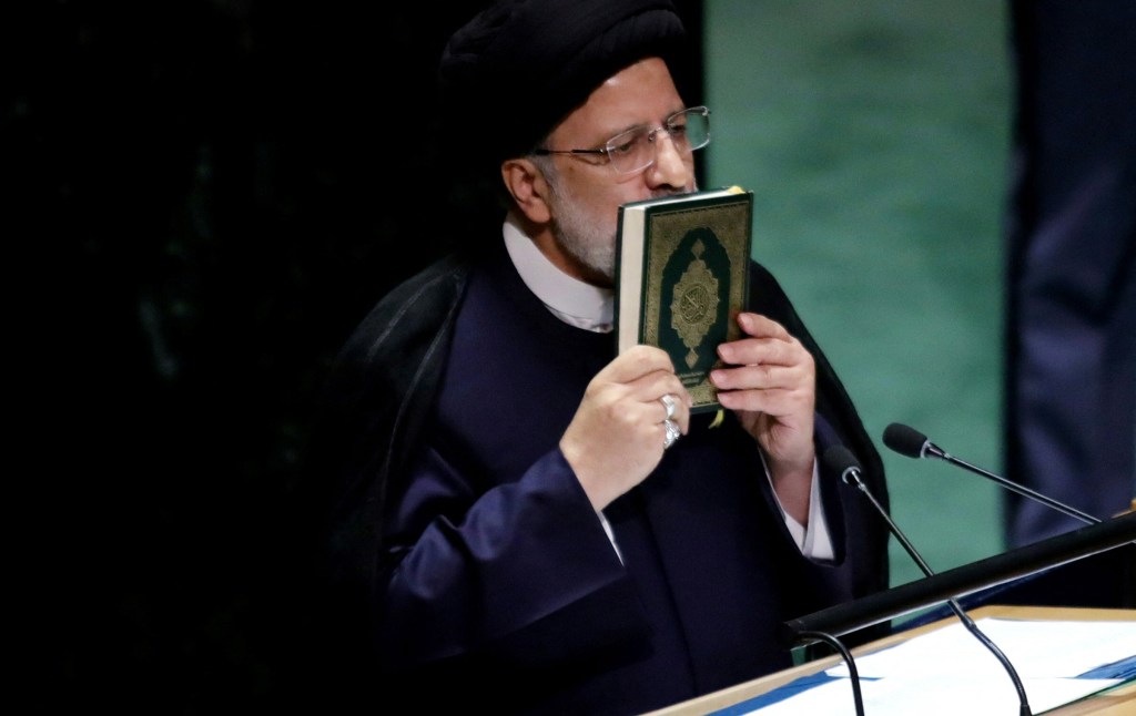 Iranian President Ebrahim Raisi kisses a Qua'ron 