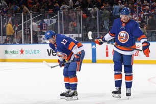 Mathew Barzal #13 and Noah Dobson #8 of the New York Islanders leave the ice following a loss to the Carolina Hurricanes in Game Three of the First Round of the 2024 Stanley Cup Playoffs at UBS Arena on April 25, 2024 in Elmont, New York. The Hurricanes defeated the Islanders 3-2.