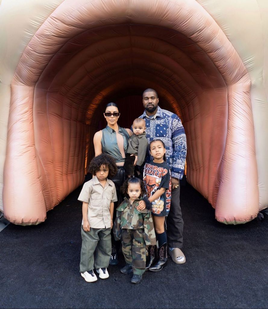 Kim Kardashian and Kanye West standing with family in a tunnel at StormiWorld party