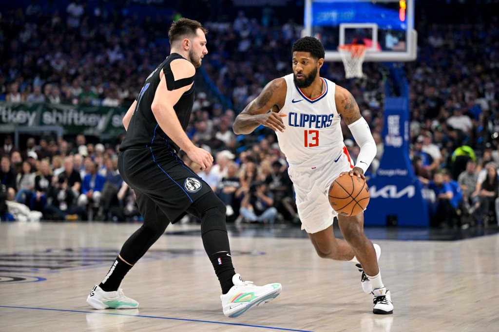 Clippers forward Paul George (13) moves the ball past Dallas Mavericks guard Luka Doncic