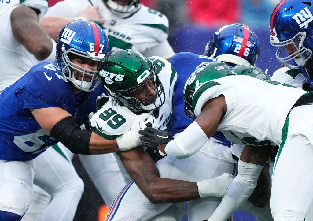 New York Jets defensive lineman Will McDonald IV (99) tackles New York Giants running back Saquon Barkley (26) during the first half of an NFL football game, Sunday, Oct. 29, 2023, in East Rutherford, N.J.