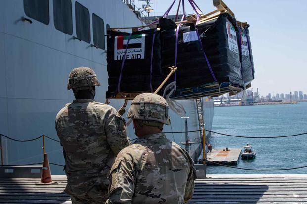 Soldiers assigned to the 7th Transportation Brigade (Expeditionary) use a rope to stabilize humanitarian aid while it is lifted by a crane aboard the MV Roy P. Benavidez at the Port of Ashdod, Israel, May 14, 2024. 