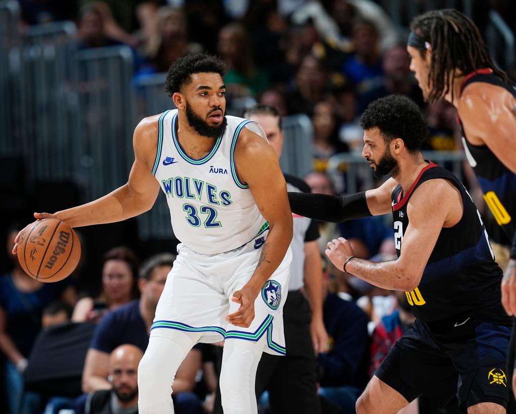 Minnesota Timberwolves center Karl-Anthony Towns, left, looks to drive to the basket as Denver Nuggets guard Jamal Murray, center, and forward Aaron Gordon defend in Game 7 of their second-round playoff series May 19, 2024, in Denver.  
