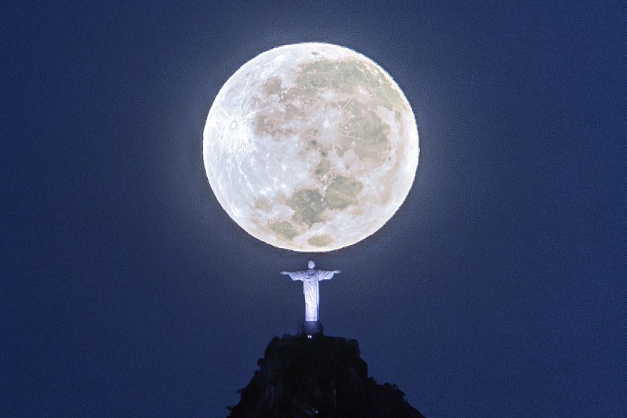 Moon sets behind the Christ the Redeemer monument in Rio de Janeiro, Brazil.