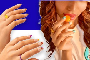 A woman with brightly painted nails holding a piece of candy on her finger