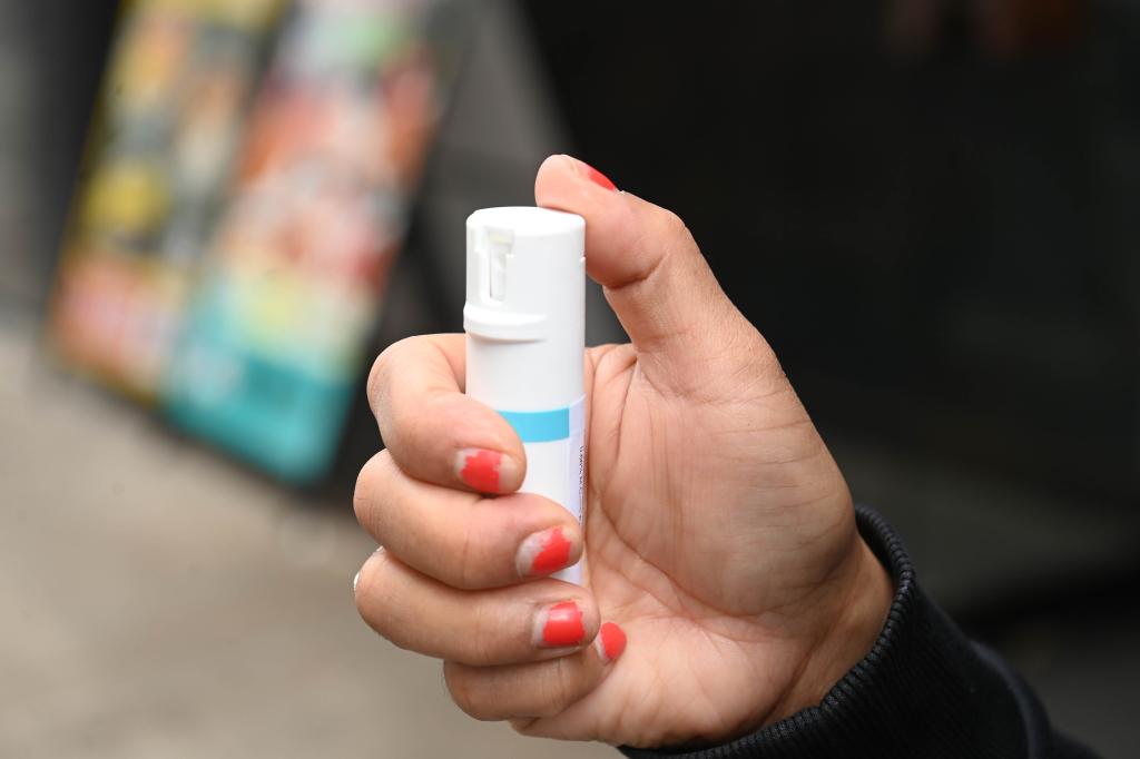 A photo of a cannister of pepper spray in a woman's hand.