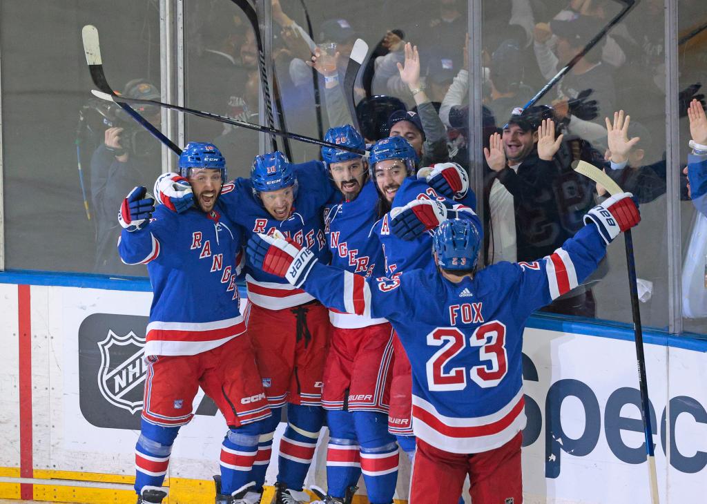 New York Rangers left wing, Chris Kreider #20, celebrating with teammates including Mika Zibanejad and Artemi Panarin after scoring a goal, during the 2024 NHL Playoffs 2nd round game against Carolina Hurricanes