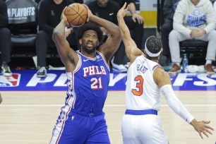 Joel Embiid, who scored 39 points, looks to make a pass around Josh Hart during the Knicks' 118-115 series-clinching win over the 76ers in Game 6.