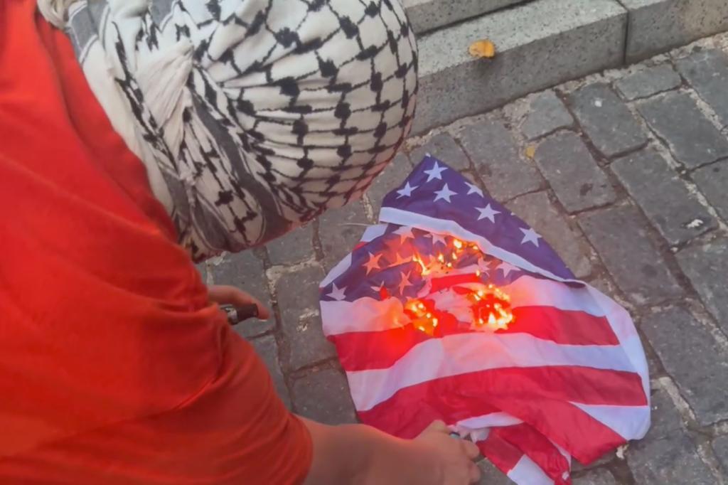 Another protester torched an American flag in front of the bronze memorial depicting seven WWI foot soldiers in battle. 