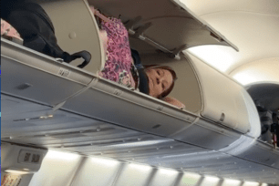 Video shows the unnamed person nonchalantly lying lengthwise in the overhead locker as if preparing for cryogenic sleep.