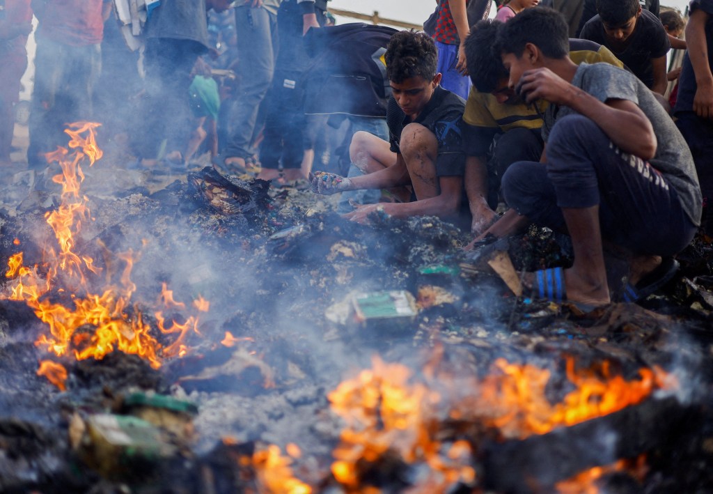 Real photos show children looking for food that survived Sunday's baze.