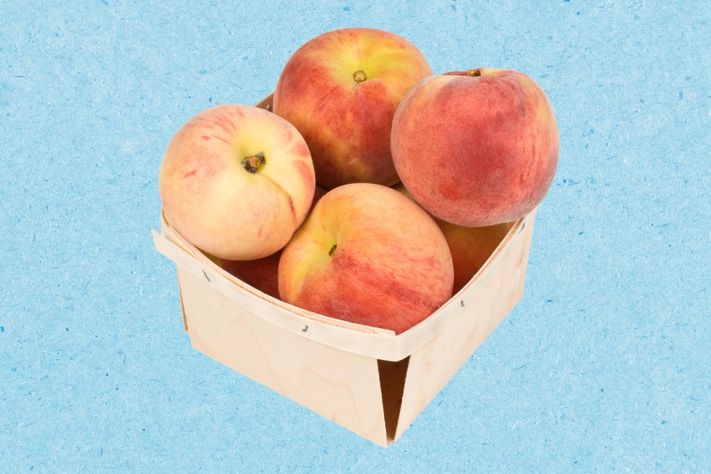 A basket of peaches on a blue paper texture background