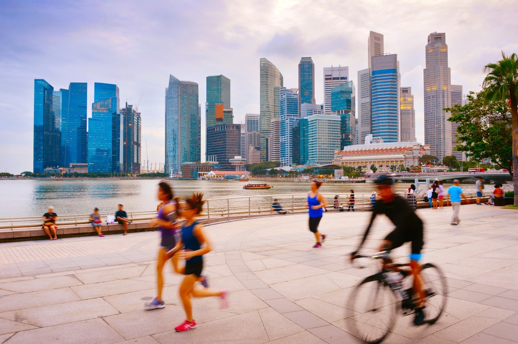 people running and cycling outside in a city setting