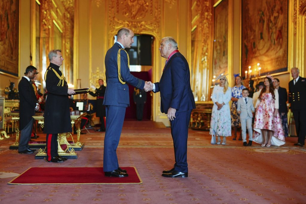 Prince William bestowing the Commander of the Order of the British Empire honor upon Peter Shilton for his services to football and the prevention of gambling harm at Windsor Castle