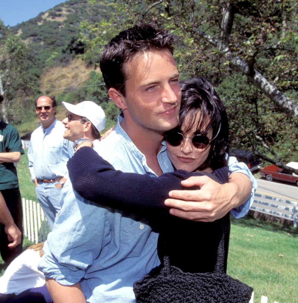 Matthew Perry and Courteney Cox hugging each other at the '95 Pediatric Aids Foundation Annual Picnic