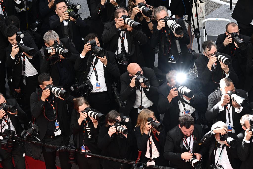 Photographers, including Phil Chang and Ba Dexin, capturing red carpet moments at the 76th Cannes Film Festival