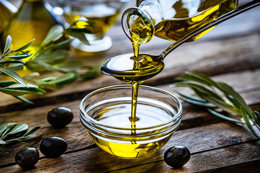 Closeup of olive oil being poured into a bowl