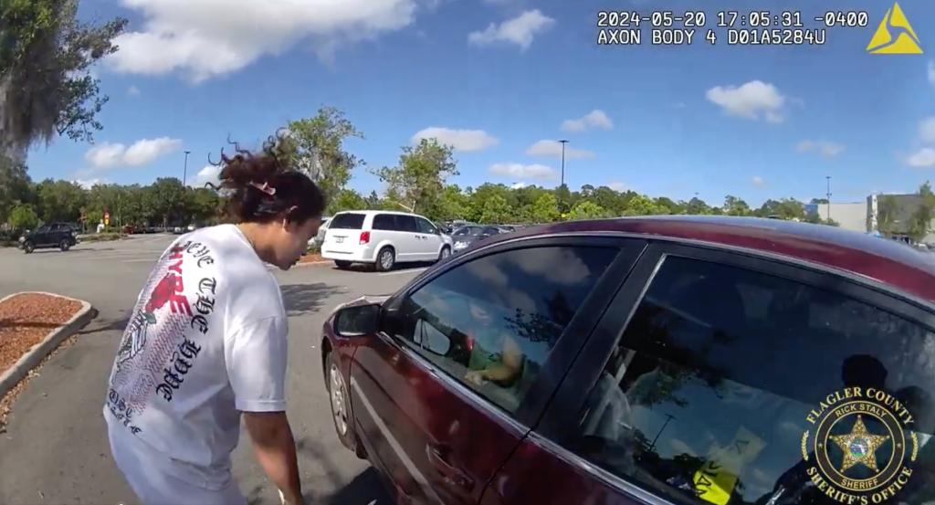 A woman looks through the car window at the toddler. 