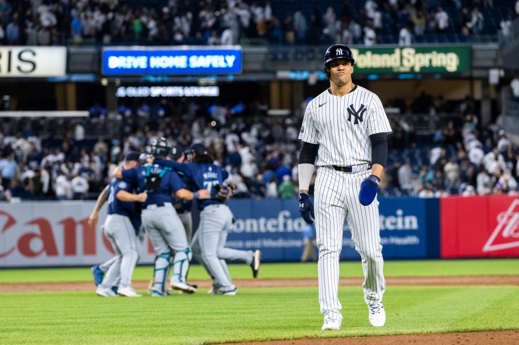 Yankees outfielder Juan Soto (22) reacts as he walks back to the dugout as the Seattle Mariners celebrate behind him after the final out of the 9th inning. The Seattle Mariners defeat the New York Yankees 5-4